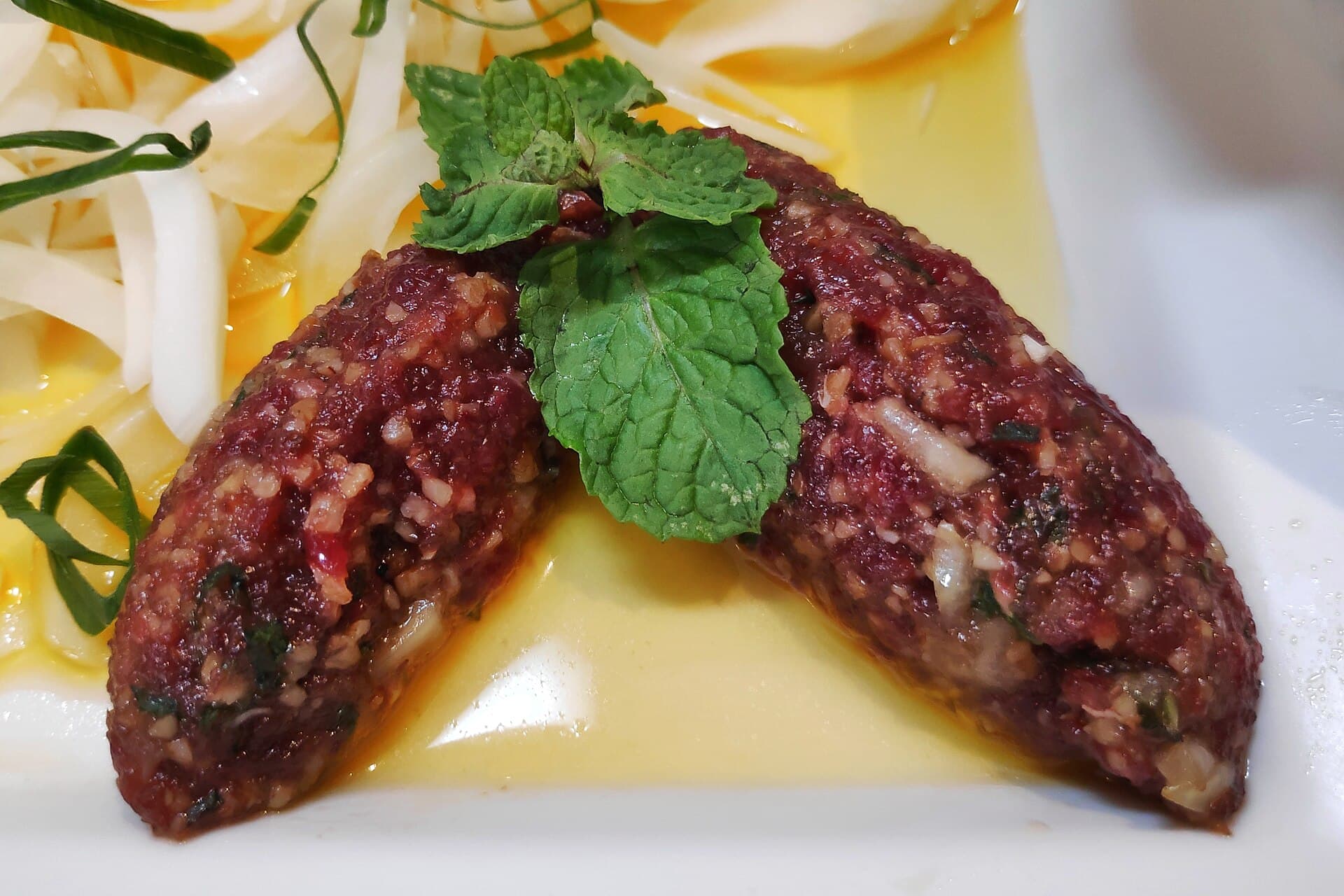 Raw kibbeh nayyeh with a mint leaf