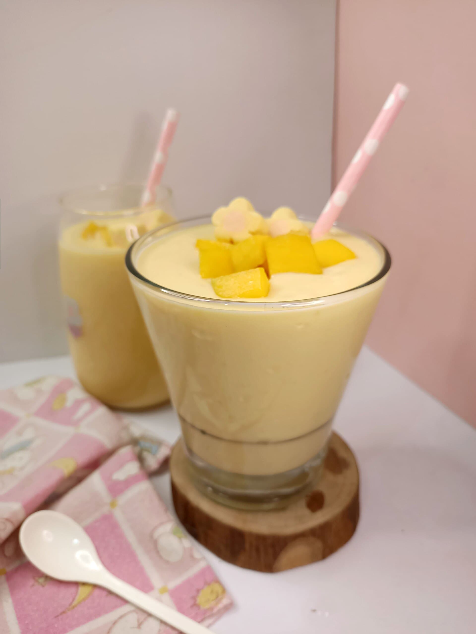 A creamy mango smoothie topped with mango