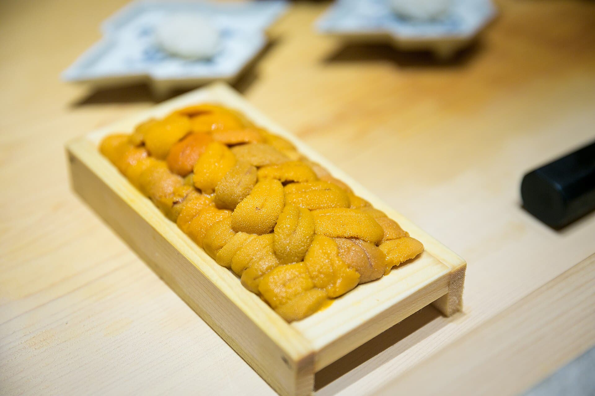 A wooden tray of fresh sea urchin (uni)